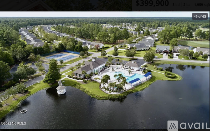 A bird's eye view of a residential area with a swimming pool and a lake.