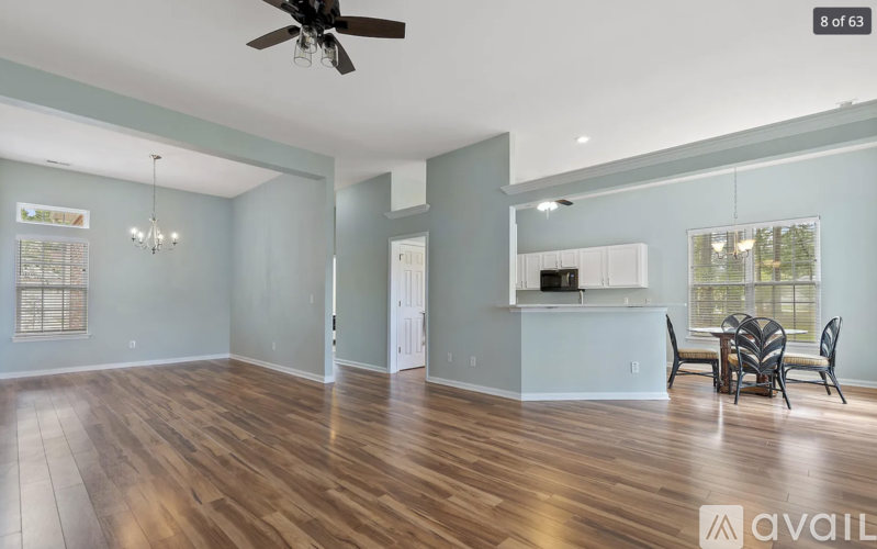 A spacious room with a ceiling fan and wooden flooring.
