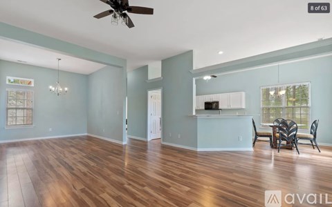 A spacious room with a ceiling fan and wooden flooring.