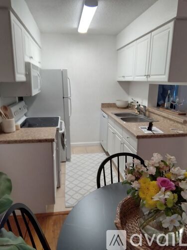 A kitchen with a table and chairs and a fridge.