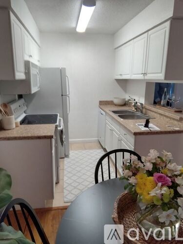 A kitchen with a table and chairs and a fridge.