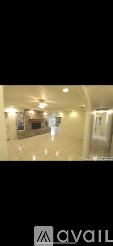 A spacious room with a fireplace and a large mirror on the wall.