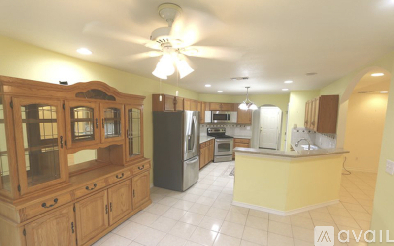 A kitchen with wooden cabinets and a black refrigerator.