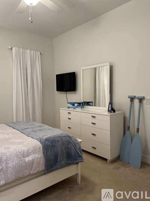 A bedroom with a bed, dresser, and mirror.
