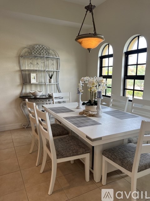 A dining room with a white table and chairs.