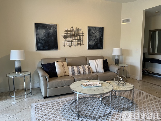 A living room with a grey couch, a coffee table, and two lamps.