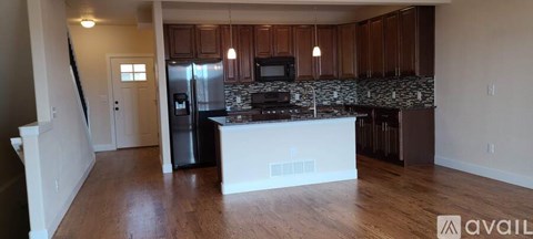 A kitchen with wooden cabinets and a black fridge.