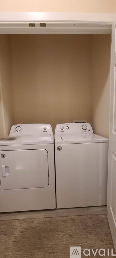 Two white washing machines in a small room.