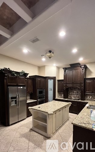 A kitchen with a marble countertop and wooden cabinets.