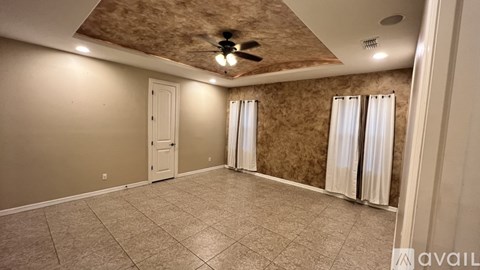 A room with a ceiling fan and a door.