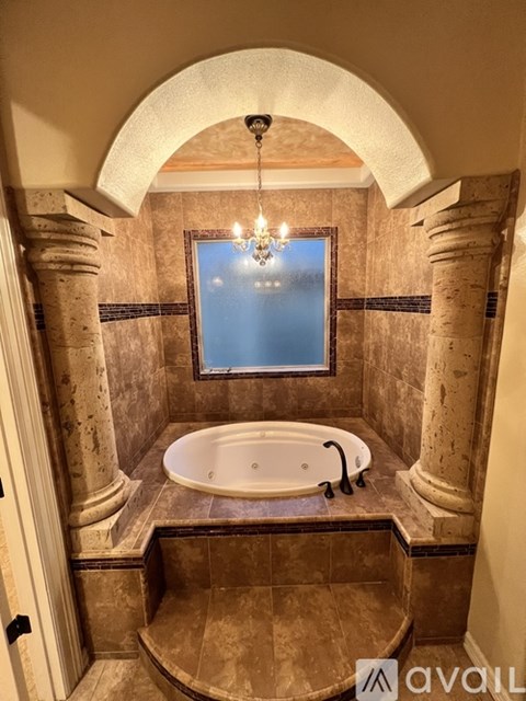A bathroom with a tub and a chandelier.