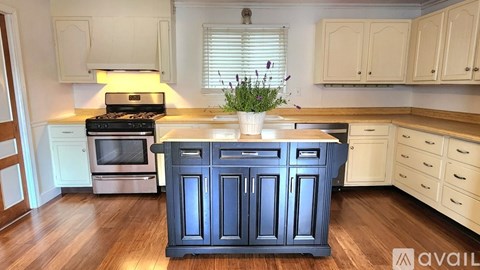 A kitchen with a blue island in the middle.