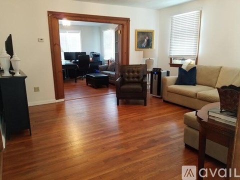 A living room with a brown leather chair and a beige couch.