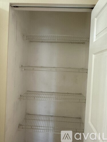 Empty shelves inside of a white refrigerator.