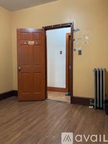 A room with a brown door and a white wall.