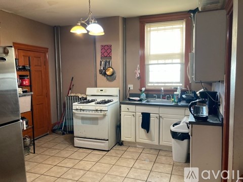 A kitchen with a white stove and a refrigerator.