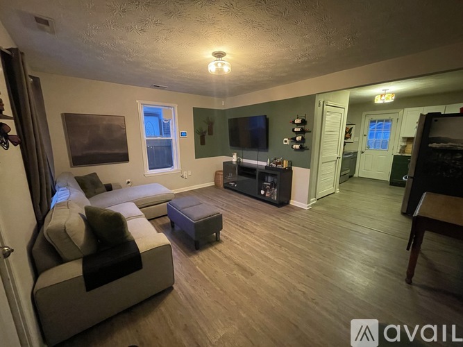 A living room with a grey couch and a wooden floor.
