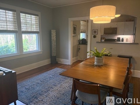 A dining room with a wooden table and chairs.
