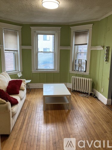 A living room with a white couch and a wooden floor.