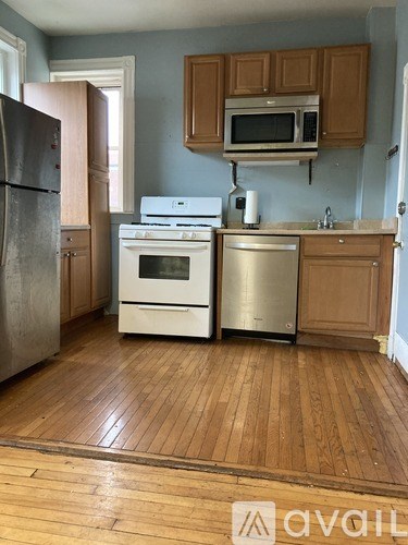 A kitchen with wooden floors and a white stove top oven.