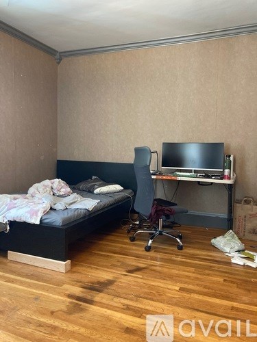 A bedroom with a bed, desk, and chair.