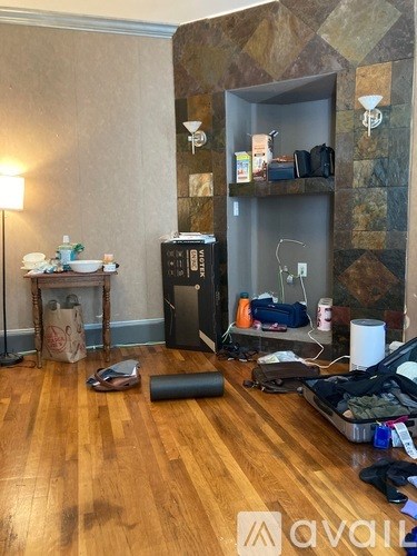 A room with a wooden floor and a shelf with various items on it.