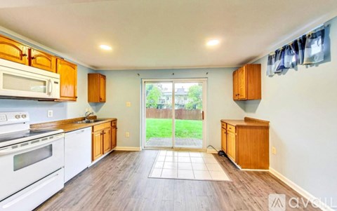 A kitchen with white appliances and wooden cabinets.