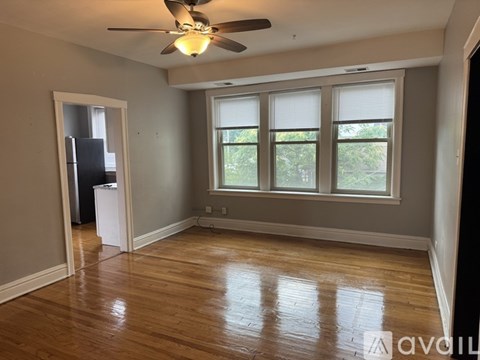 A room with a ceiling fan and wooden flooring.