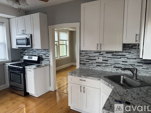 A kitchen with white cabinets and a granite countertop.