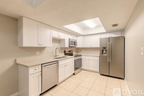 A kitchen with white cabinets and appliances.