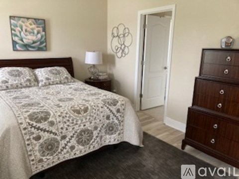 A bedroom with a bed, nightstand, and dresser.