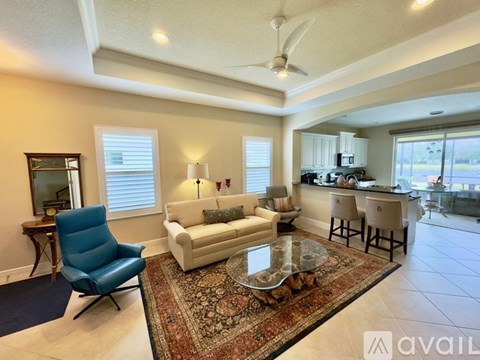 A living room with a blue chair and a white couch.