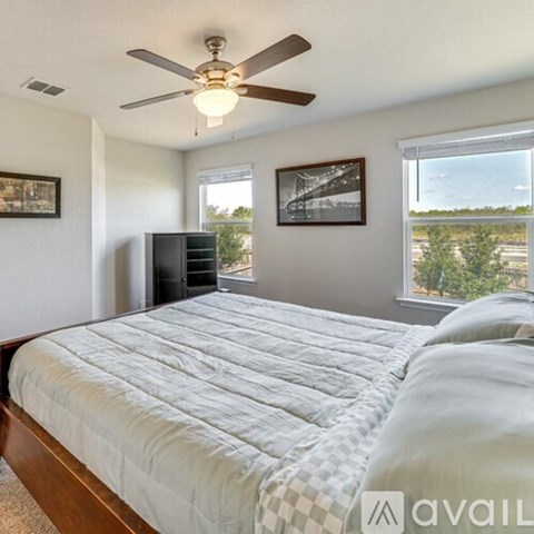 A bedroom with a large bed and a ceiling fan.