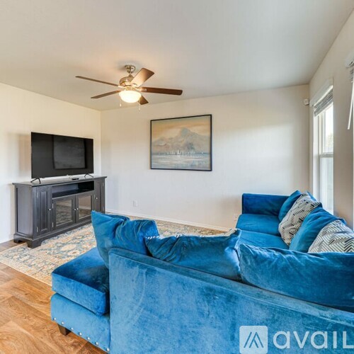 A living room with a blue couch and a television.