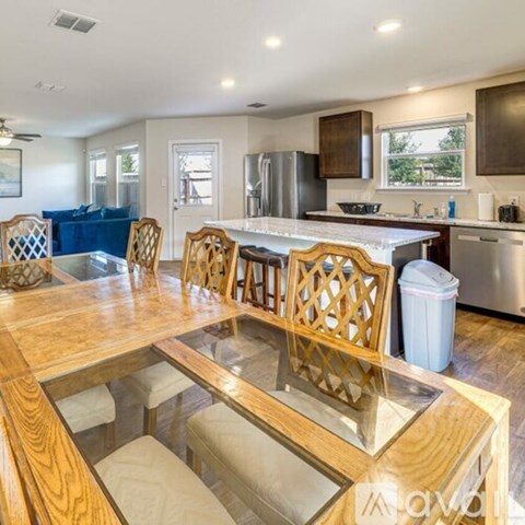 A kitchen with a wooden table and chairs.