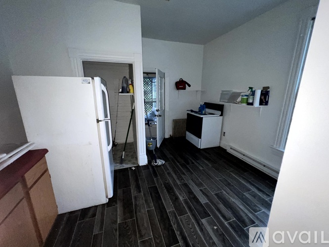 A kitchen with a white fridge and a black floor.