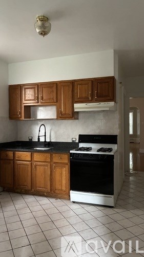 A kitchen with wooden cabinets and a black countertop.