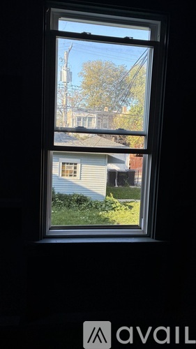 A window with a view of a house and trees outside.