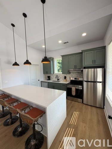 A kitchen with a white counter top and stools.