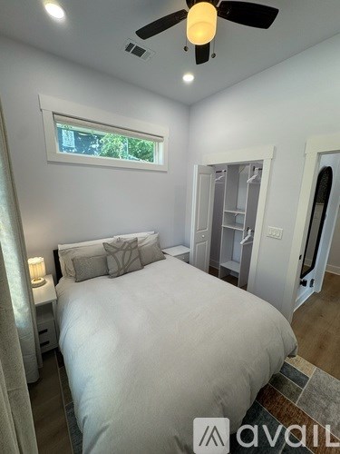 A bedroom with a large bed and a ceiling fan.