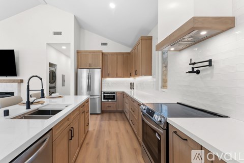 A modern kitchen with wooden cabinets and stainless steel appliances.