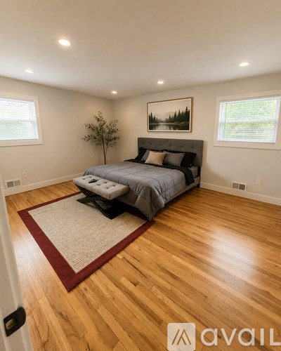 A bedroom with a large bed and a painting on the wall.