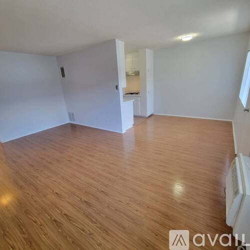 A room with wooden flooring and white walls.