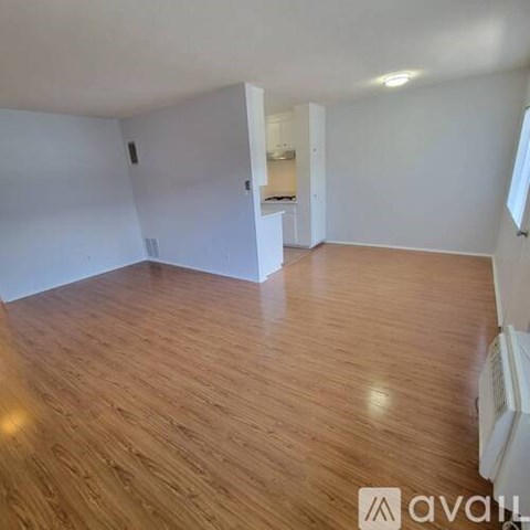 A room with wooden flooring and white walls.