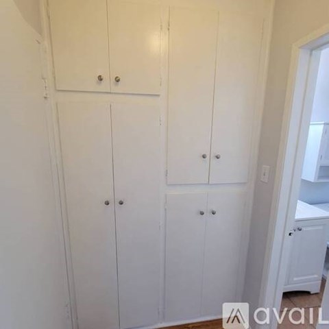 A set of white cupboards with silver handles.