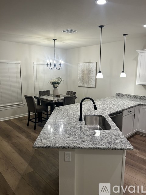 A kitchen with granite countertops and a dining table with chairs.