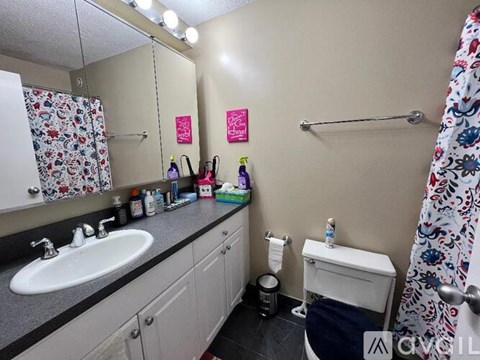A bathroom with a sink, toilet, and shower.