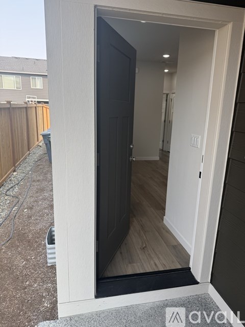 A white door is open to a hallway.