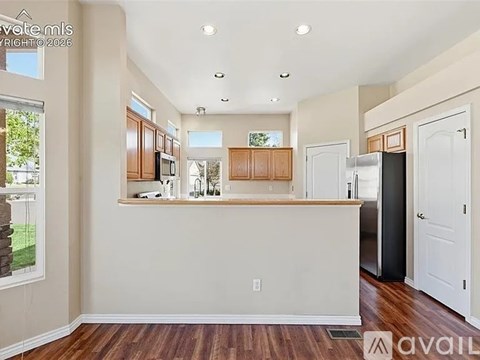 A kitchen with wooden cabinets and a white island.