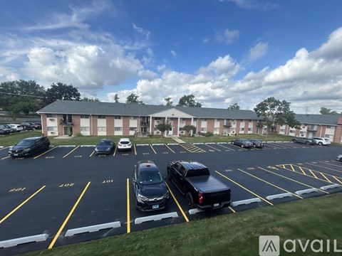 A parking lot with cars parked in it and a building in the background.